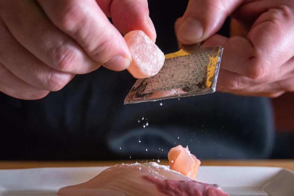 Himalayan pink salt being grated over food in a kitchen